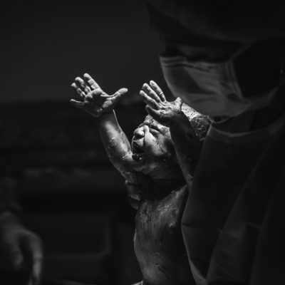 Newborn baby reaches towards light