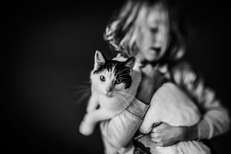 girl holding a cat, taken with a tilt-shift lens, photography on a budget