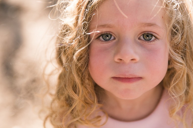 close up photo of young girl with curly hair by Kristin Dokoza