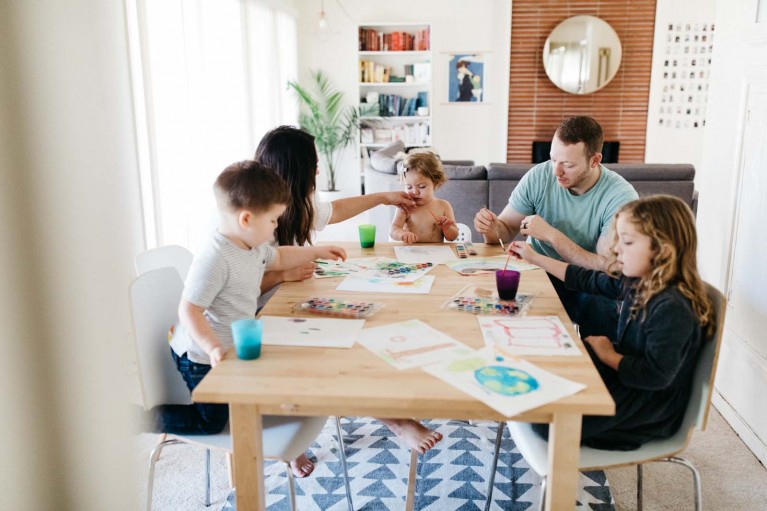A family draws at a table day in the life session of photography