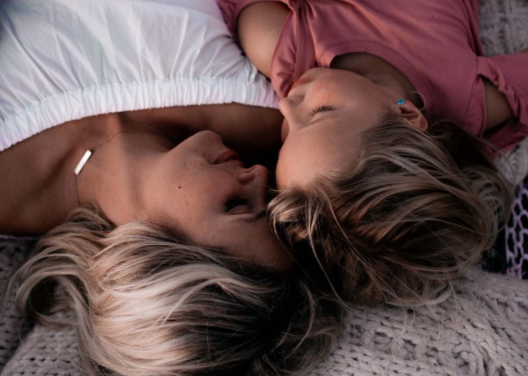 Emotional connection in photos through closed eyes, mom and daughter lay side by side