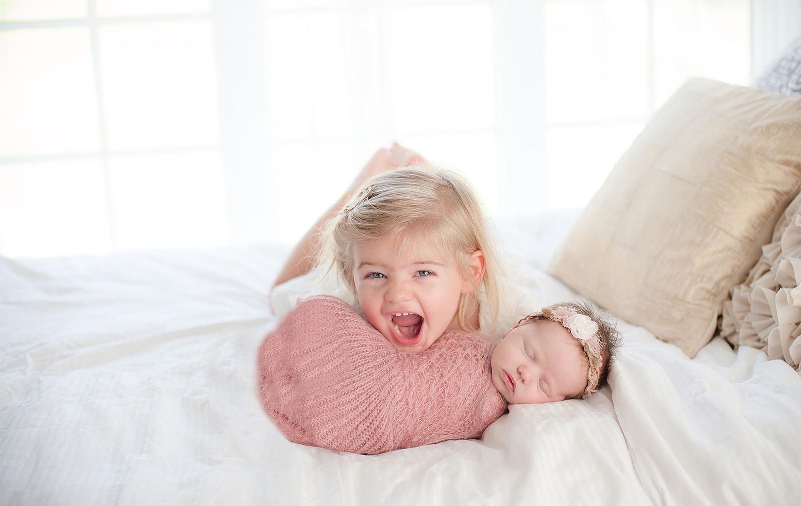 Photo of a toddler sibling with a newborn