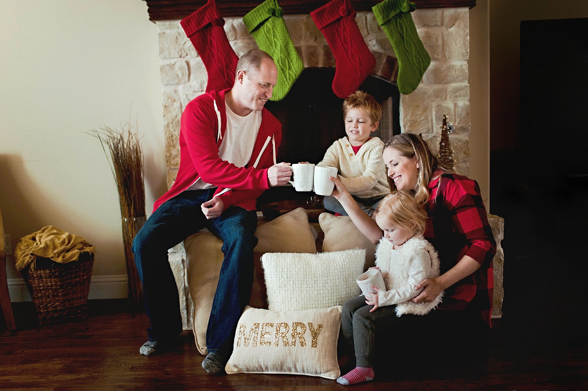 family Christmas photo by a fireplace by Erica Williams