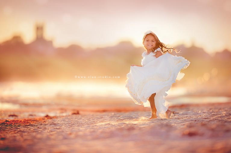 girl holding her dress while she twirls by Tracy Sweeney of Elan Studio