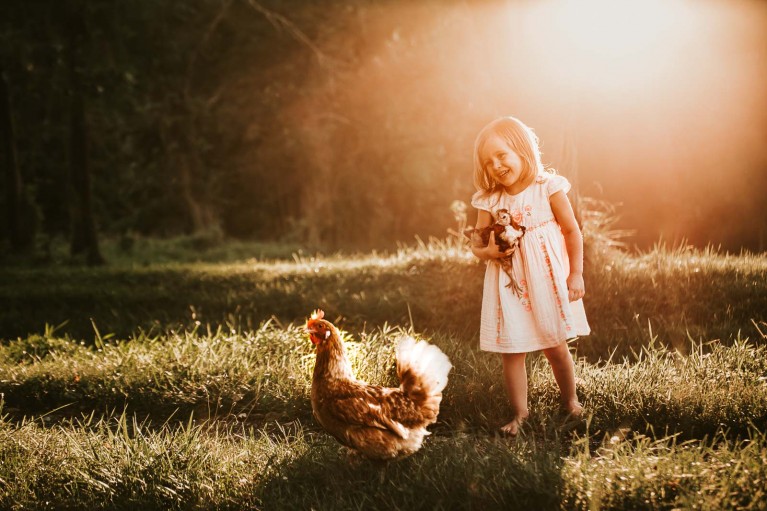 Little girl with her pet chickens