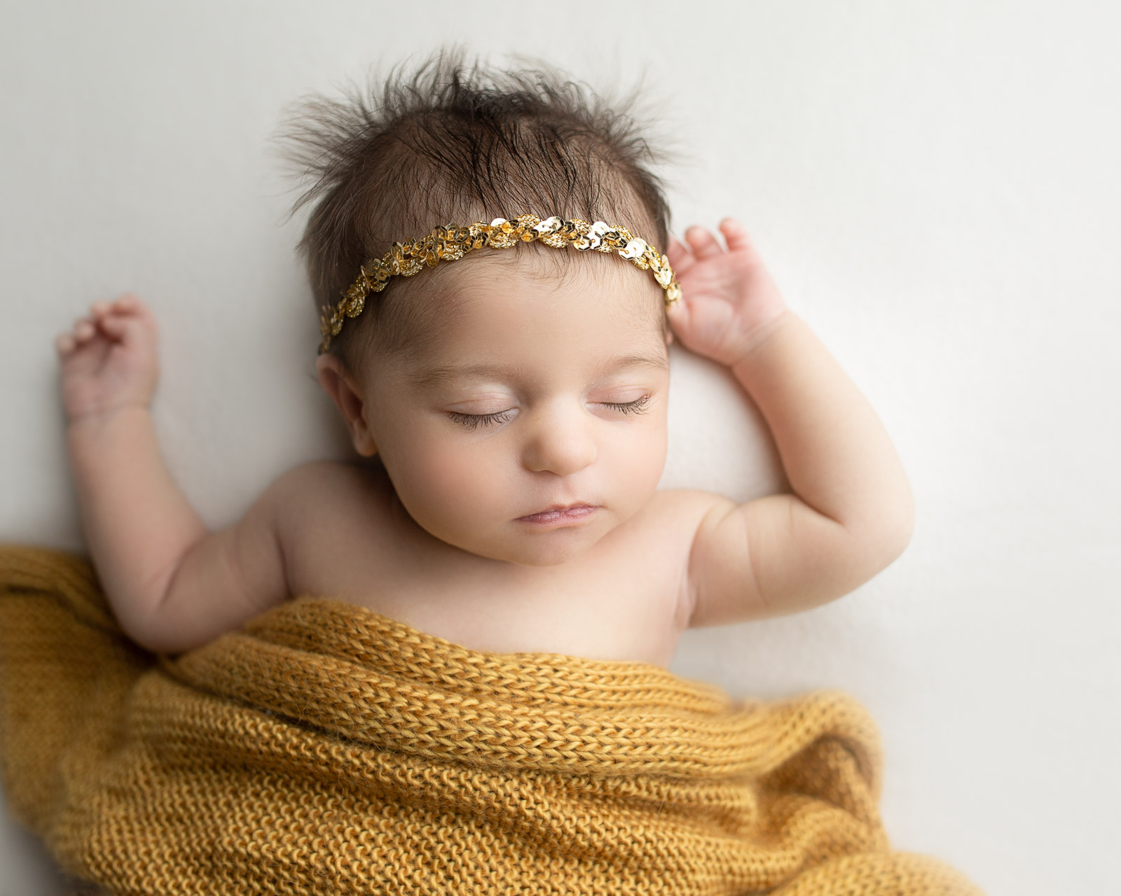 No-stress newborn pose of baby with arms up