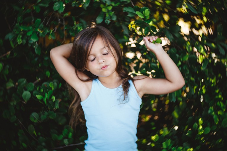 photo of a girl holding a flower taken with the Lensbaby Twist 60 by Carolina Gonzalez