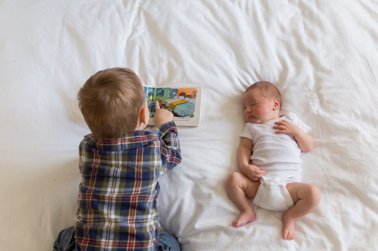 photo of brother reading to newborn by Jaye McLaughlin