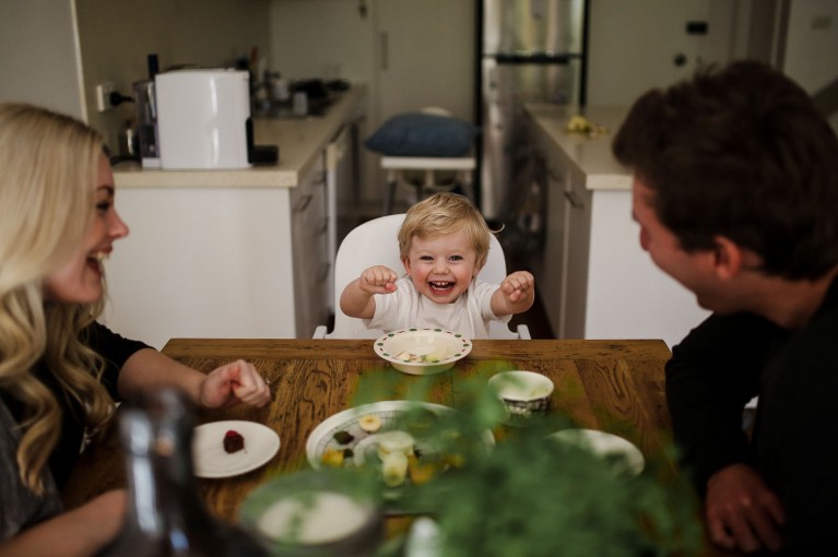 photo of toddler laughing at the kitchen table by Justine Curran