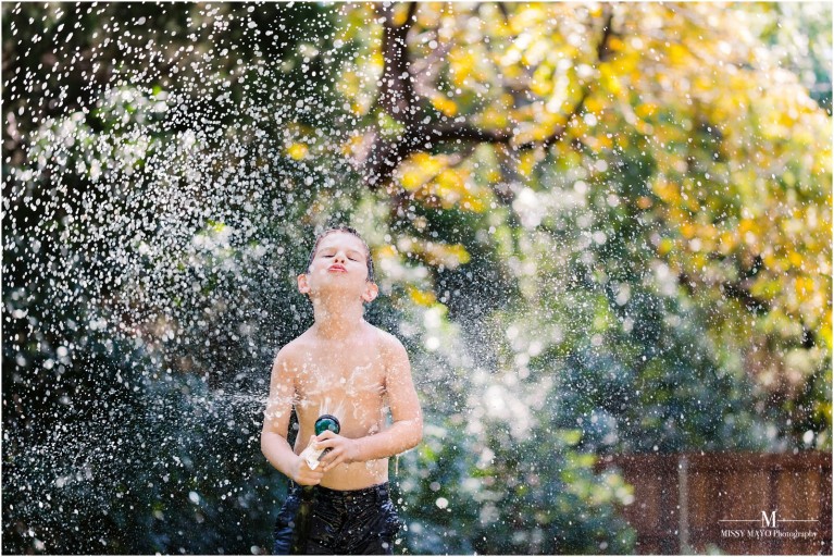 photo of water spraying on young boy by Missy Mayo