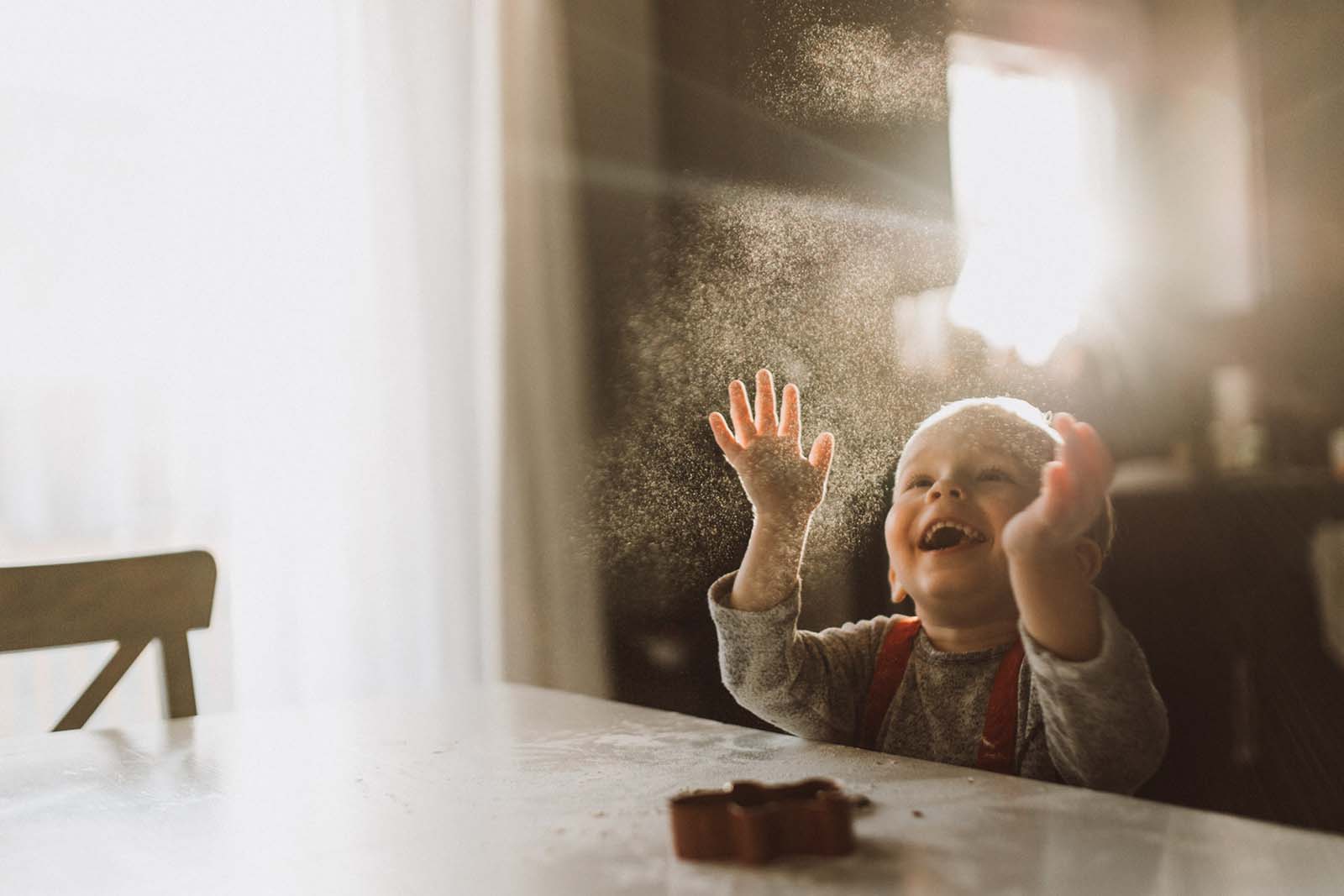 photographer-mom-laura-frazier A joyful boy through a window. Finding balance with photography and motherhood