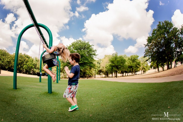picture of boy pushing his sister on a swing by Missy Mayo