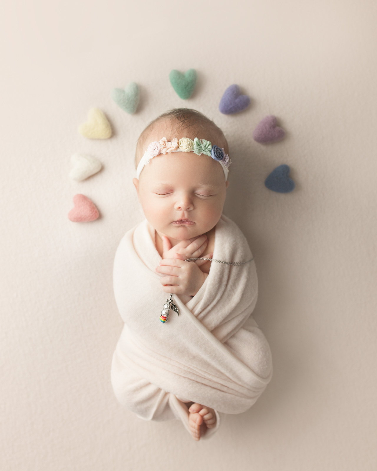 newborn baby photo with rainbows above babies head